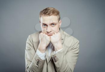 Young handsome man in  suit  looking at camera thinking or dreaming