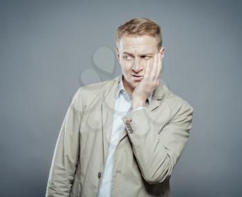 young businessman with teethache and frustration in business suit