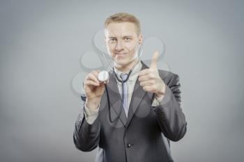 healthcare and medical concept - doctor with stethoscope showing thumbs up