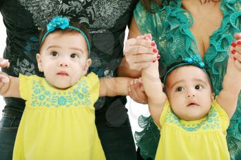 Dad and mom holding her twin babies girl