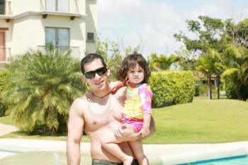 Father and daughter beside the swimming pool 