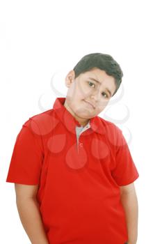 Portrait of a happy little young boy standing with hands in pocket over white background 
