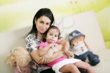 Mother and daughter in the waiting room at doctors office.