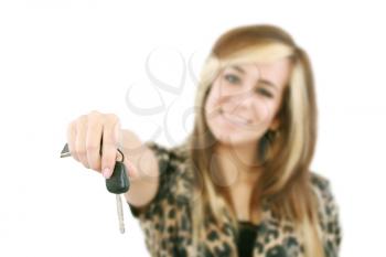 Young caucasian woman holding car key. Image with shallow depth of field. The key is in focus. 

