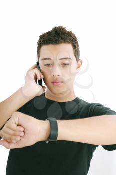 Portrait of a busy young male using mobile phone and looking at watch