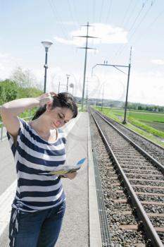 Young woman confused on which direction to choose in a empty railroad