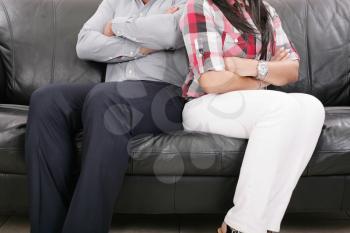 Couple sitting of the couch having problems in their relationship
