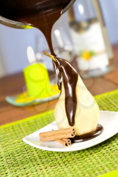 Pouring chocolate on a poached pear