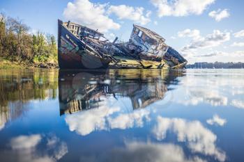 Wooden wreck boat sinking in the clouds