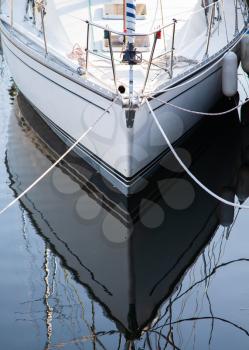 Boat hull at the port reflecting symmetrical in the water