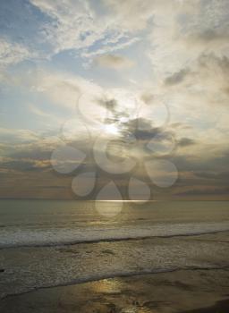 Sun shining though the clouds at sunset at Tanah Lot Temple area, Bali, Indonesia