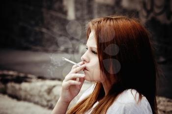 Closeup portrait of smoking beautiful young girl