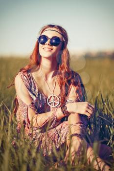 Portrait of a beautiful young hippie girl in the field