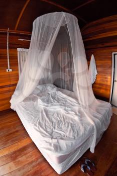 Mosquito net on the bed in Thai bungalow
