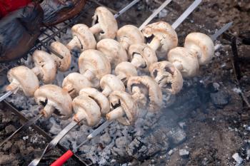Mushrooms in smoke on bbq grill
