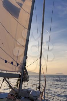 Sailboat crop during the regatta at sunset ocean
