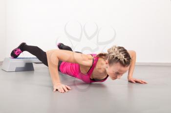 Athletic young woman doing exercises in the gym
