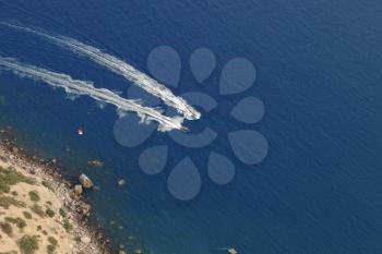 Speed boats racing in the sea, top view
