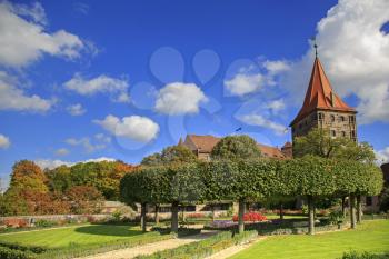 Nuremberg Castle with blue sky and trees in garden
