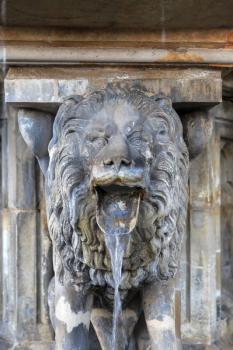 Lion statue with streaming water from mouth near Cologne cathedral, Germany
