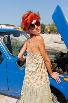Vintage girl posing in front of the car summer day

