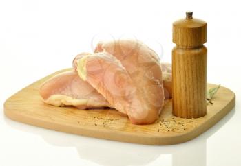 Raw chicken breast meat on wooden chopping board 