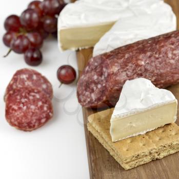 Brie Cheese And Salami On A Wooden Board
