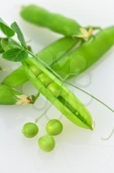 Fresh green pea pods and peas on white background.