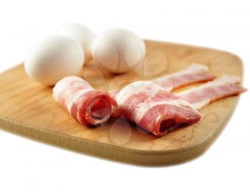 bacon and eggs on a cutting board