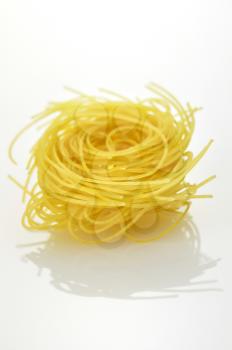 Raw pasta nest on a white background
