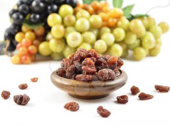 grape and raisins in a wooden bowl