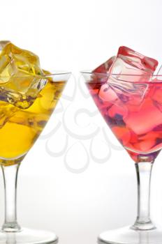 red and yellow drinks with ice cubes, close up