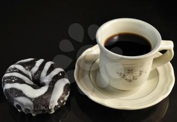 donut  and cup of coffee on black background