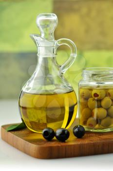 A bottle of olive oil with olives
