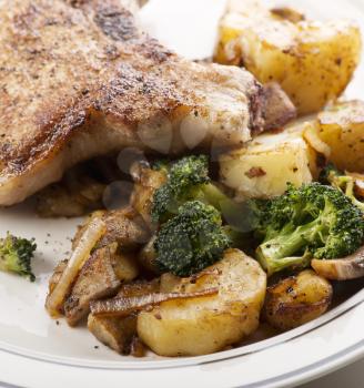 pork chops with potatoes broccoli and onions,close up