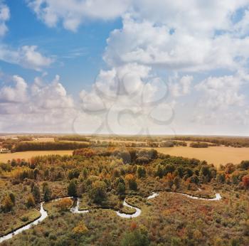 Beautiful countryside with a small river and autumn trees. Aerial landscape.