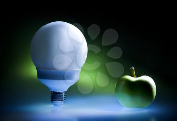 Enercy saving bulb and green apple, concept of green energy