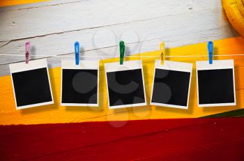 Blank picture frame hanging on clothesline on wood background