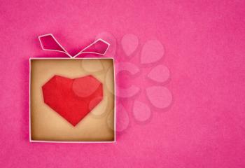 Hand made gift box with heart inside, textured  paper as background. Greeting card 