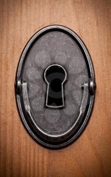 Closeup of an old keyhole on a wooden door