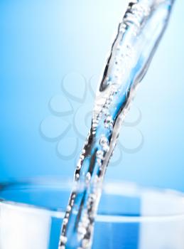 Pouring water to a glass, close up photo