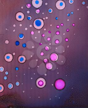 Bright pink round spots on purple.Colorful background hand drawn with bright inks and watercolor paints. Color splashes and splatters create uneven artistic modern design.