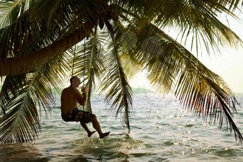 Royalty Free Photo of a Person On a Swing in the Adaman Sea in Thailand