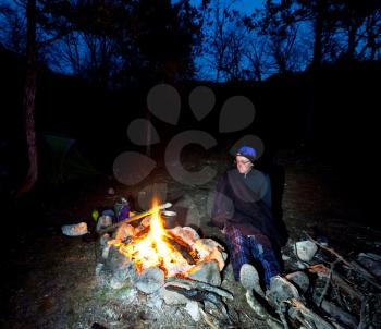 Royalty Free Photo of a Man Near a Campfire