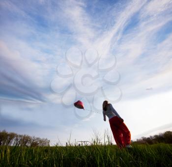 Royalty Free Photo of a Woman Flying a Balloon
