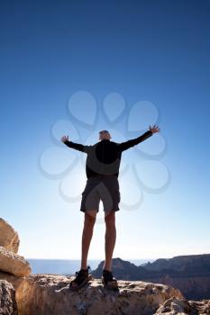 Royalty Free Photo of a Man Standing on a Cliff