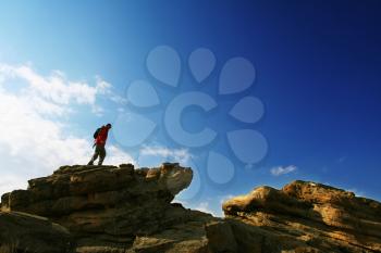 Royalty Free Photo of a Backpacker Standing on a Rock