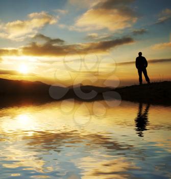 Royalty Free Photo of a Silhouette of a Man at a Lake