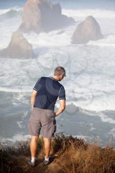 Royalty Free Photo of a Man Looking at the Pacific Ocean Coast