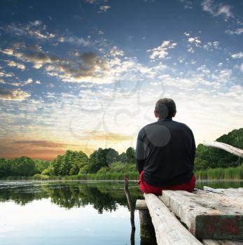 Royalty Free Photo of a Man Sitting at a Lake